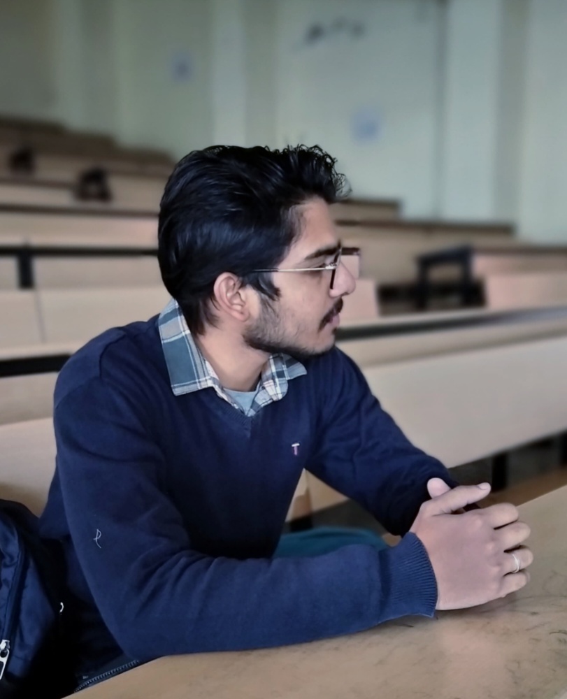 Professional profile of Vansh Garg in a navy sweater, looking thoughtfully to the side.